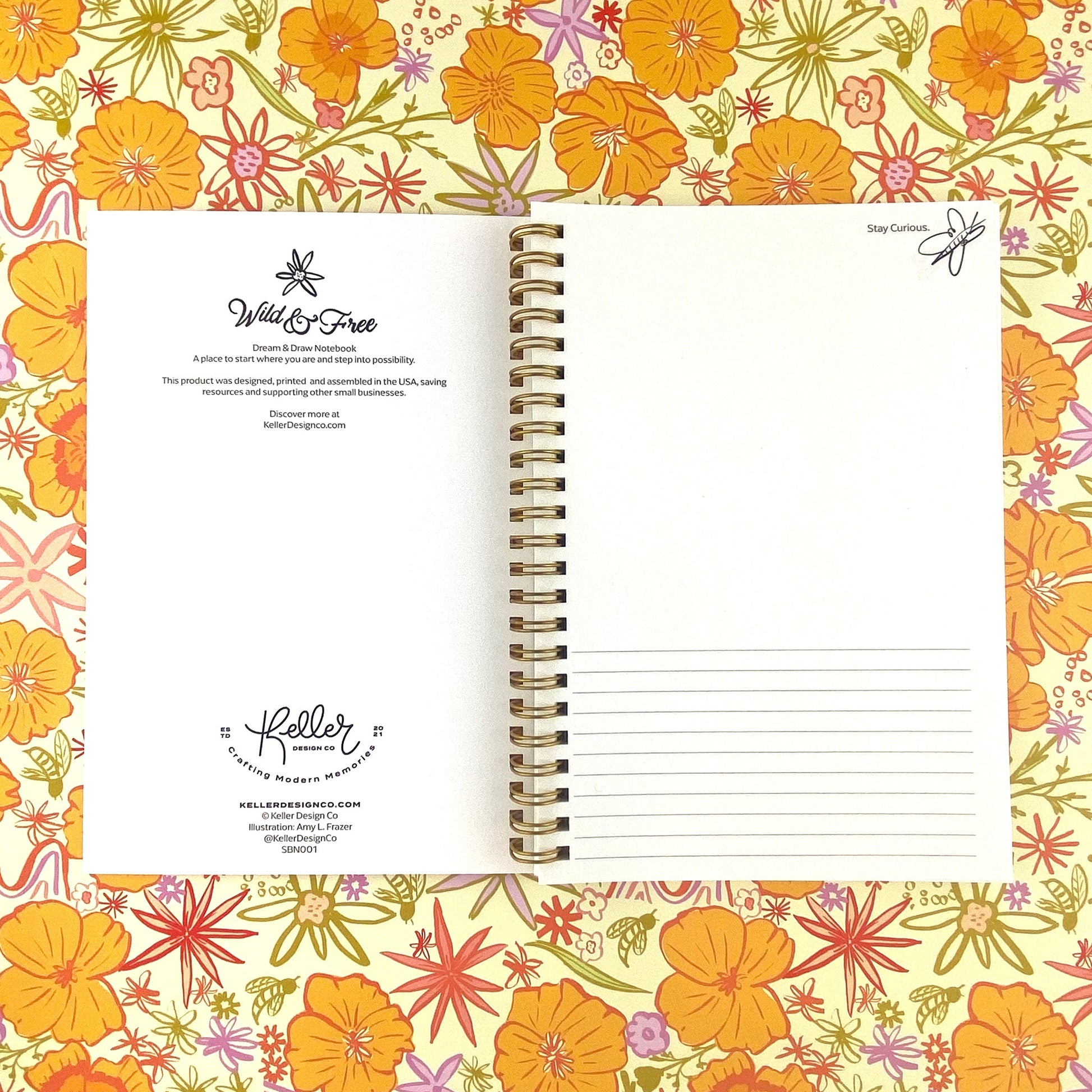 Spiral Bound Notebook with hand drawn colorful poppies and wildflowers in tones of orange , red, lavender and gold on a cream background. In the center is the handlettered phrase Wild and Free on a cream colored banner.