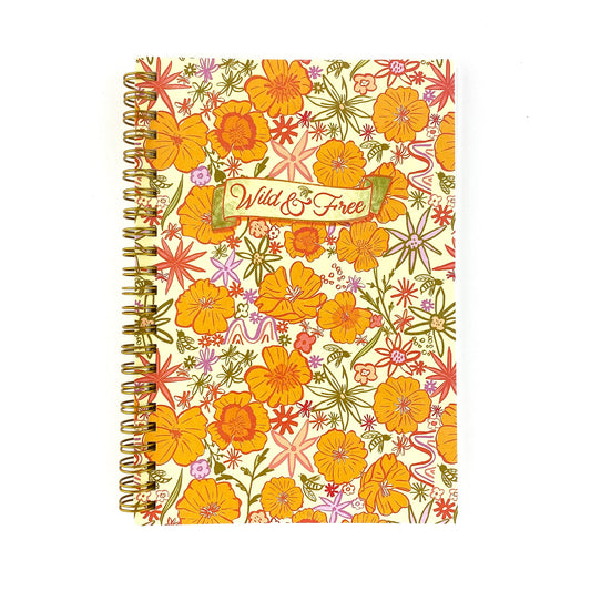 Spiral Bound Notebook with hand drawn colorful poppies and wildflowers in tones of orange , red, lavender and gold on a cream background. In the center is the handlettered phrase Wild and Free on a cream colored banner.