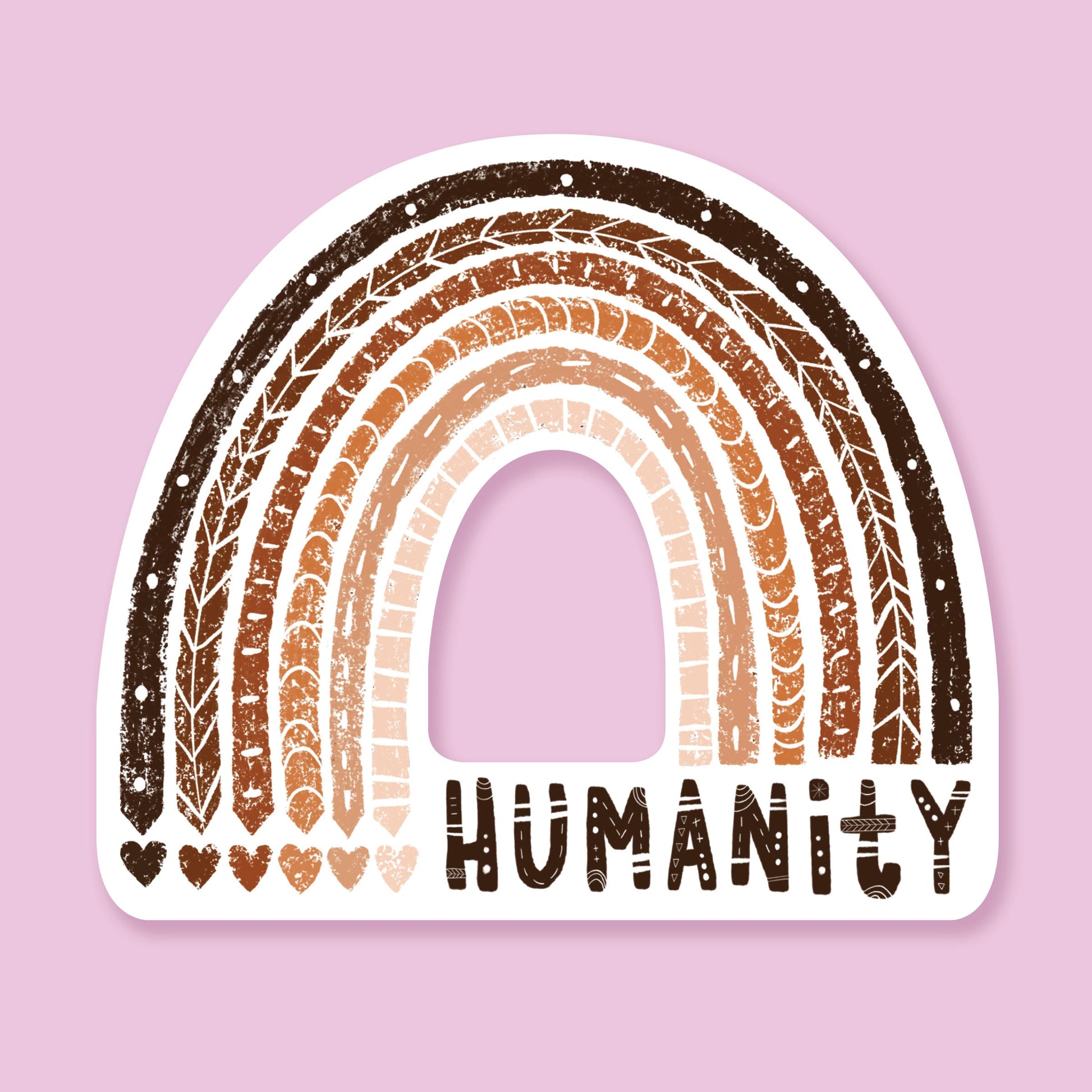 White sticker with a multicolored diverse rainbow, skintones ranging from white to dark brown. The words Humanity are hand lettered and the rainbow has decorative details. Sticker sits on a lavender background. 